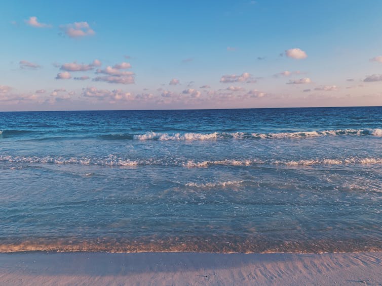 Bright blue sea laps at a beach.