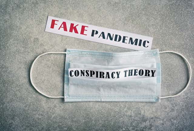 A face mask with the words 'conspiracy theory' written on