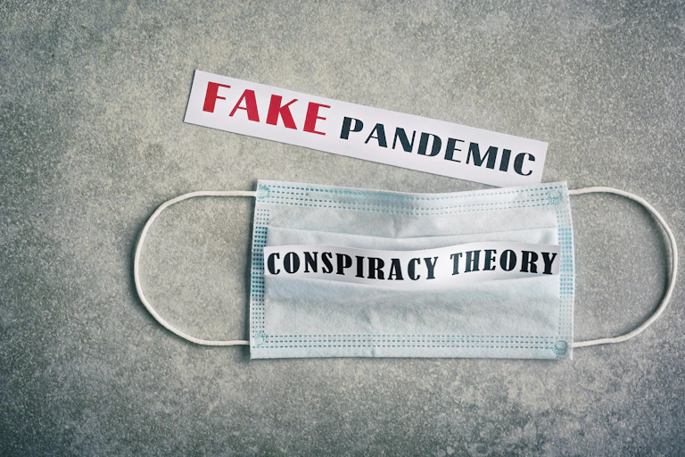 A face mask with the words 'conspiracy theory' written on