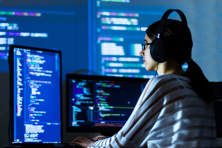 Woman coding at a desk.