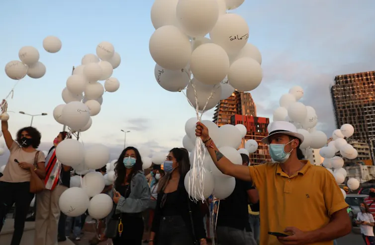 Des Libanais se rassemblent pour lâcher des ballons blancs près du port de Beyrouth