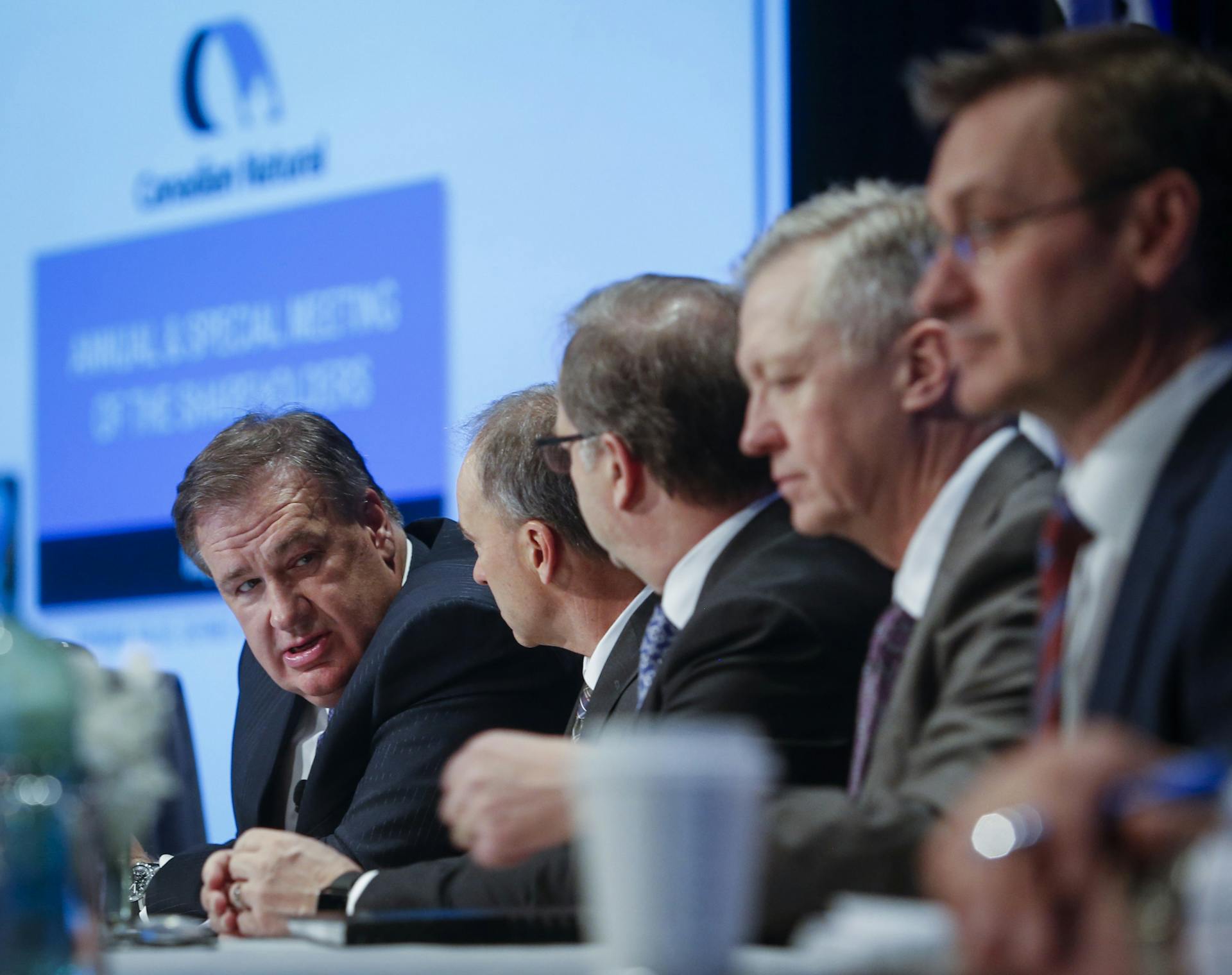Canadian Natural Resources Ltd. chairman Murray Edwards, left, prepares to address the company’s annual meeting in Calgary in May 2019. The Alberta Liabilities Disclosure Project says the province’s largest oil and gas companies are underestimating how much it will cost to clean up thousands of oil and gas wells drilled over past decades. The Canadian Press/Jeff McIntosh A panel of men at a conference
