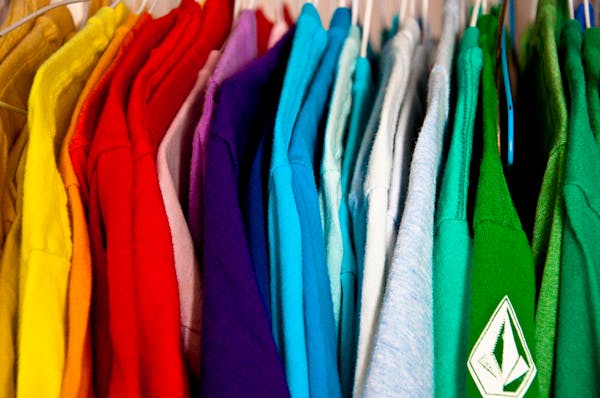 Close-up of shirts of different colors hanging in a closet