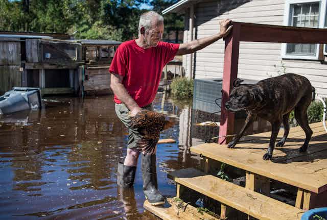 George Aubert rescues one of his chickens from rising floodwaters caused by remnants of Hurricane Matthew after it struck Fair Bluff, North Carolina, in 2016.