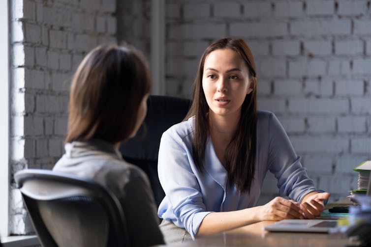 Woman consulting professional looking woman in office