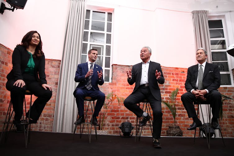 four people sitting on stools