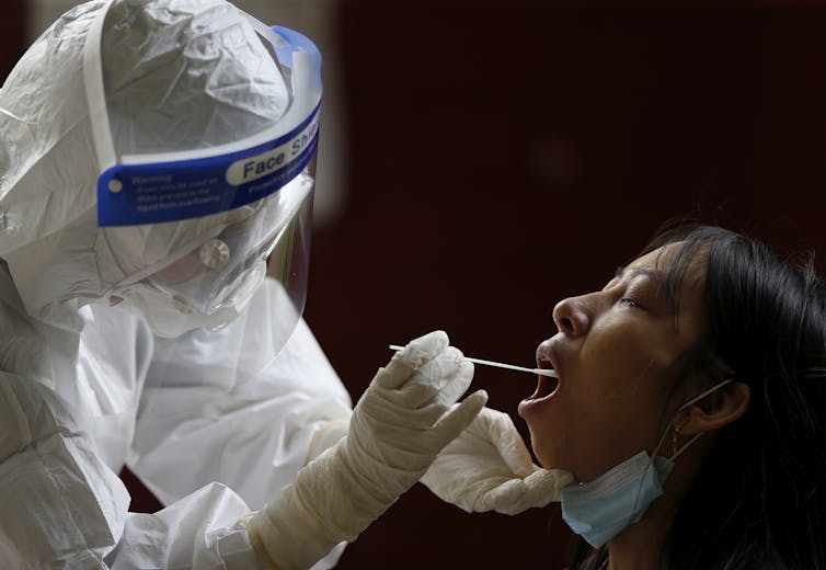 A health-care worker swabbing someone to test for coronavirus