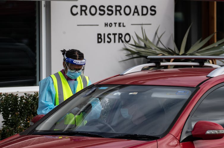 A health-care worker testing someone for coronavirus outside the Crossroads Hotel, Sydney