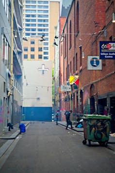 Rough sleeper packing up in Melbourne laneway