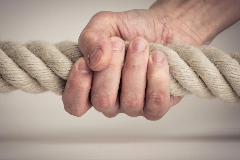 Person grips a rope tightly.