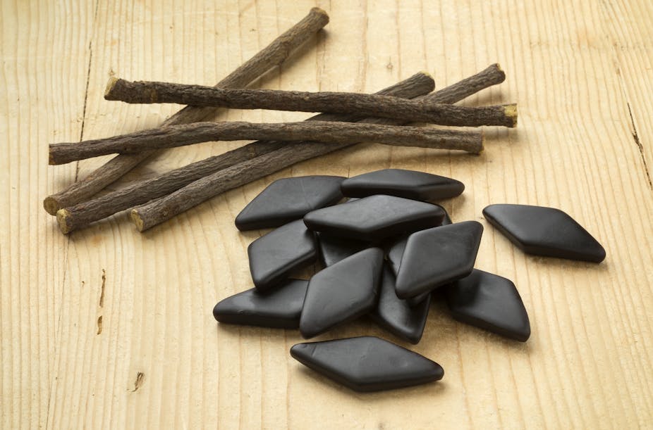 Black licorice root and black licorice candy on a table