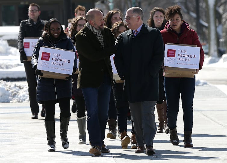 Group of people carrying boxes with the amicus brief to the Supreme Court.