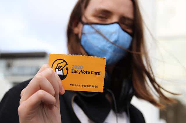 woman holding orange voting card