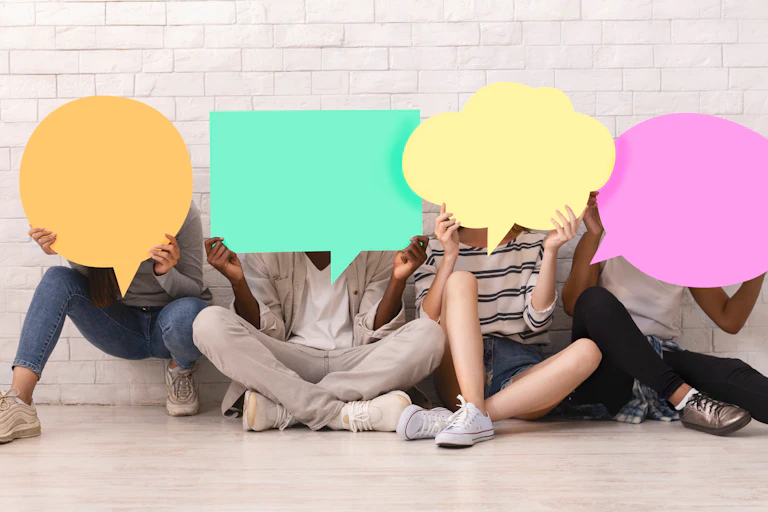 Teens hold speech bubbles in front of their faces.