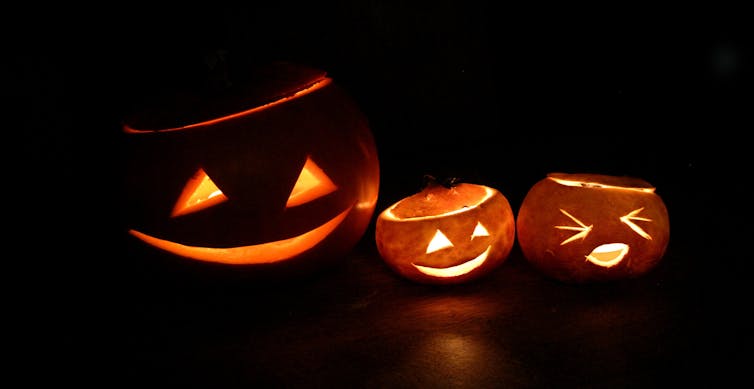 Three pumpkins carved with Halloween faces.