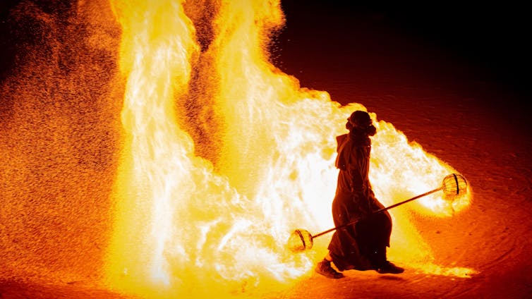 Firewalker amid blaze.