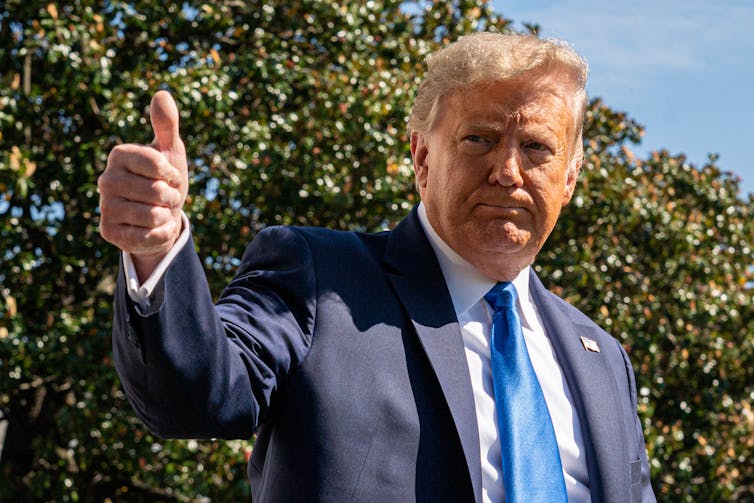 El presidente Trump levanta los pulgares.