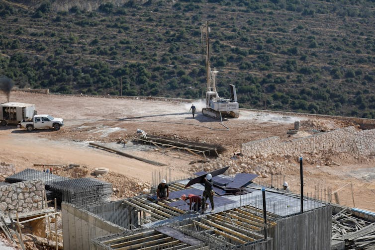 Aerial shot of a dusty building site with a concrete structure under construction