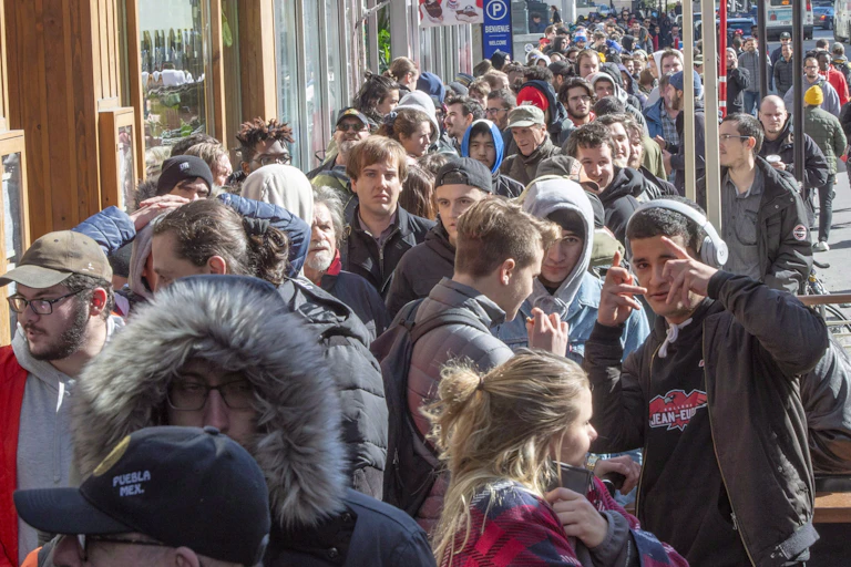 Hundreds of people in a line up on a city street.