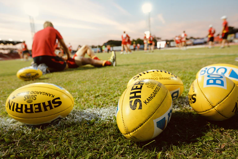 Footballs and AFL players at a training session