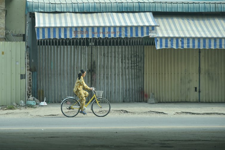 Woman rides a bicycle through Phnom Penh