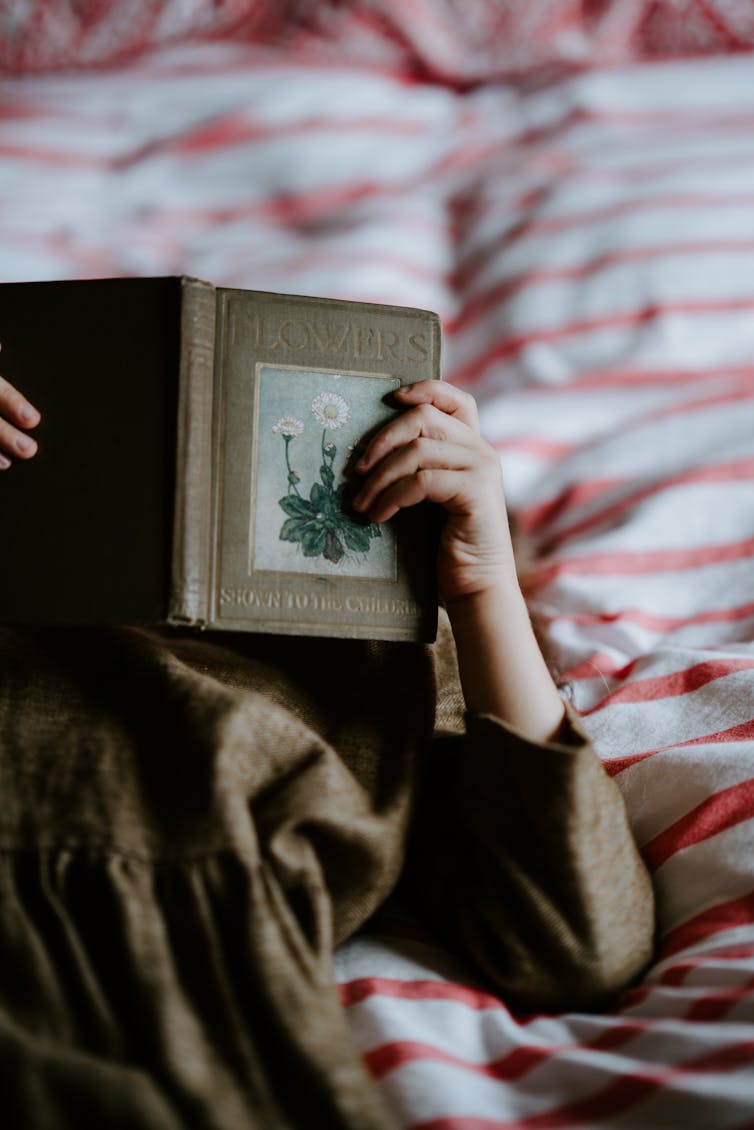 Girl reads a book in bed