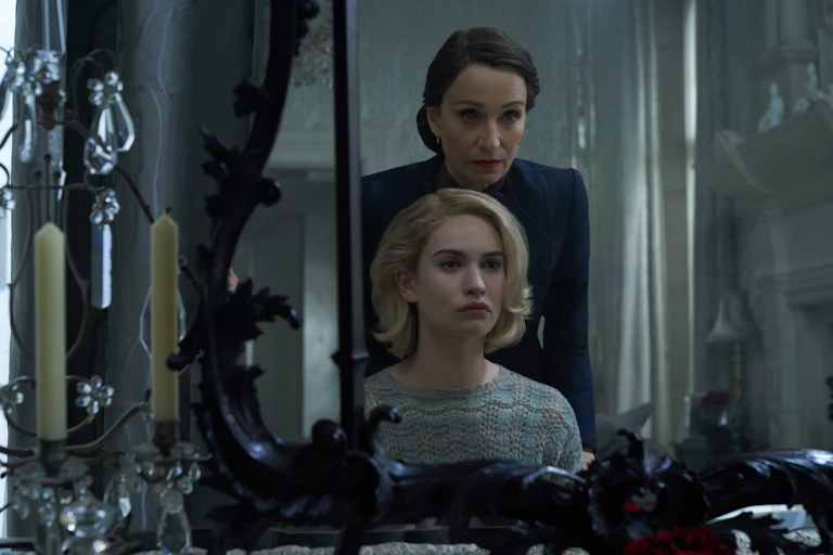 Older woman and younger woman look in antique mirror