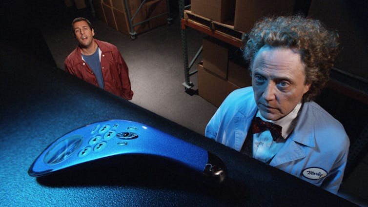 Movie still: Sandler and Walken stare at a remote