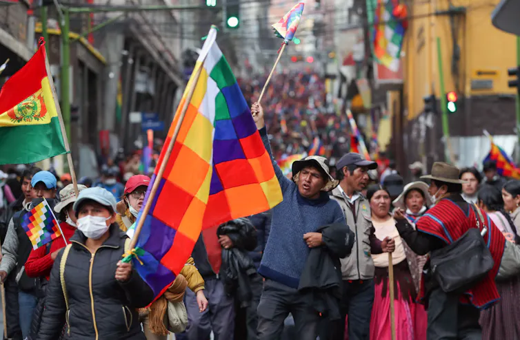 Protesters marching with the Wiphala flag.
