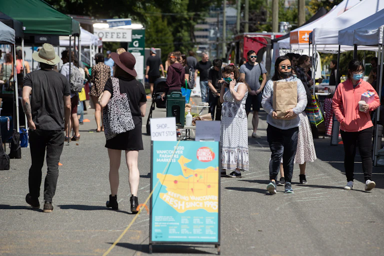 People walk through a farmers market