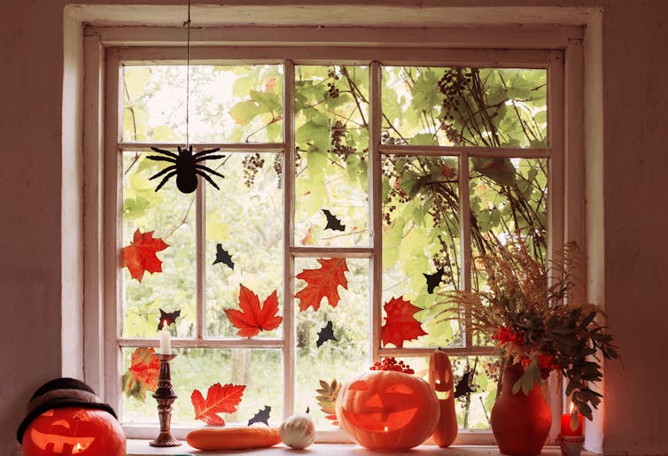 A window with leaf and spider decorations.