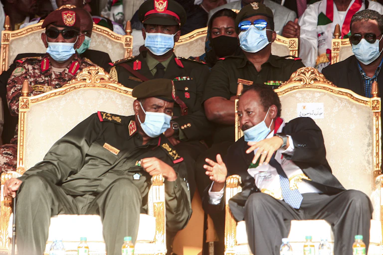 General Abdel Fattah al-Burhan (left) speaks with Prime Minister Abdalla Hamdok (right) during an October 2020 ceremony celebrating the peace deal