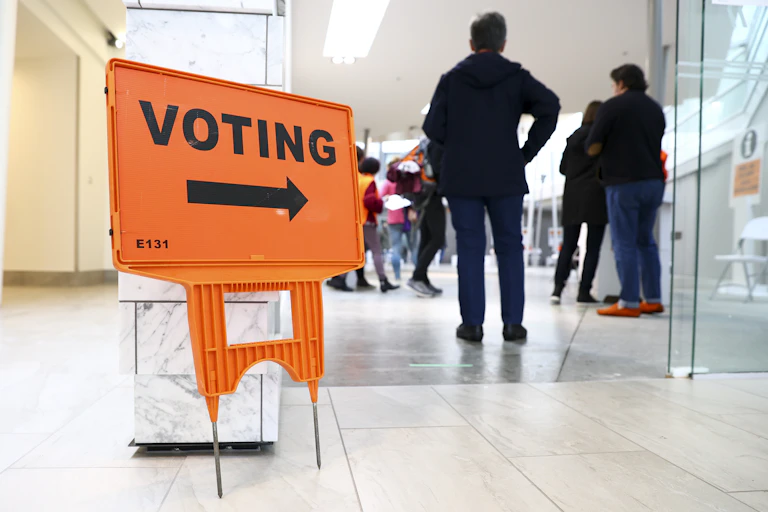 voting sign with people nearby