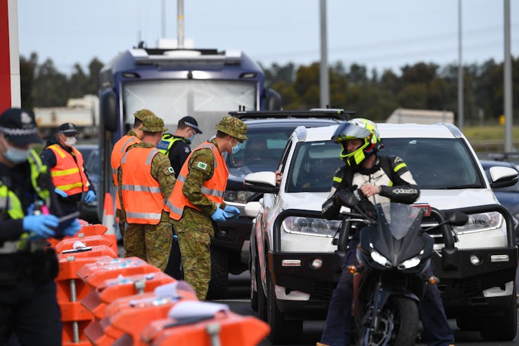 Victoria Police and ADF personnel work at a roadside checkpoint near Donnybrook, Victoria.