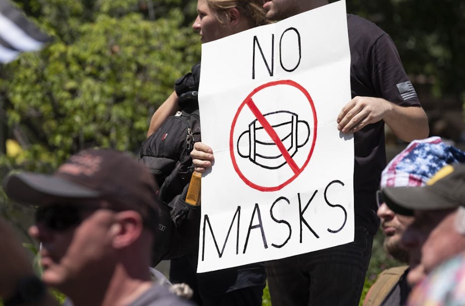 Un manifestant anti-masque brandit une pancarte le 18 juillet 2020 à Columbus, Ohio.
