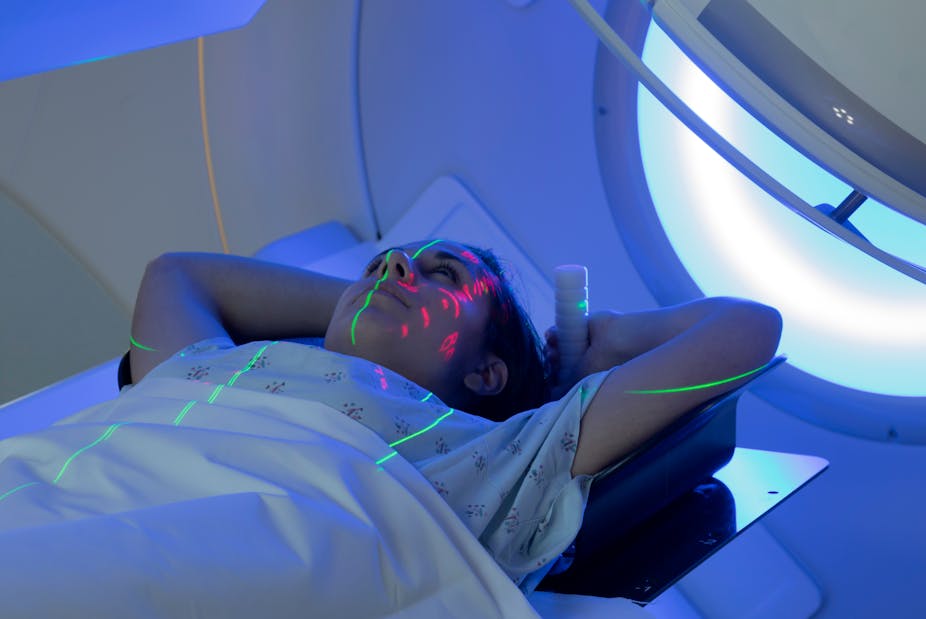 Young woman receiving radiotherapy treatment.