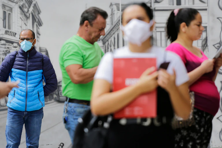 Cinco personas por la calle. Dos con mascarilla y tres sin ella.