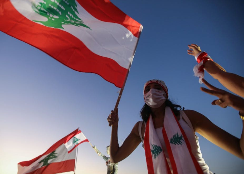 Un libanais lève un drapeau national lors d'une manifestation