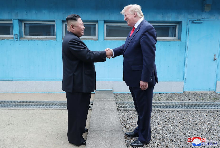 Kim Jong-un shakes hands with Donald Trump. 