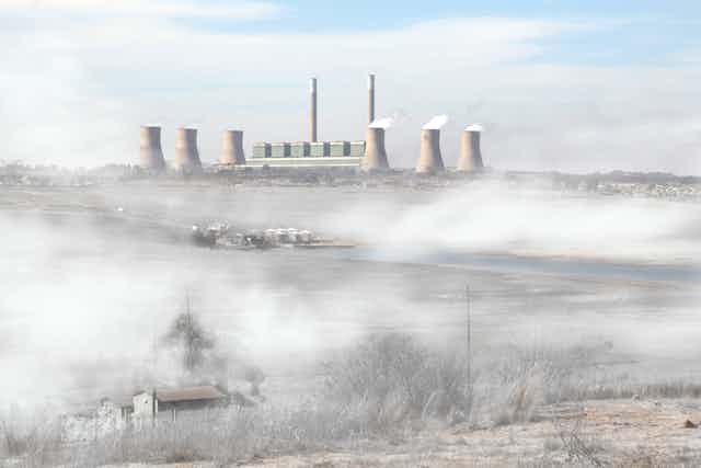 A coal plant emitting smoke into the environment. 