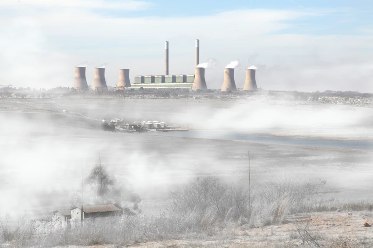 A coal plant emitting smoke into the environment.