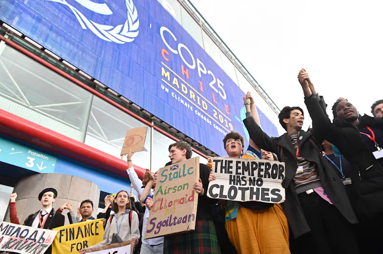 Climate protesters stand outside the 2019 climate change conference venue in Madrid, Spain.