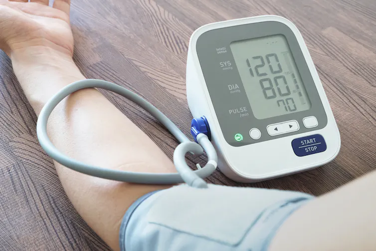 A man's arm with a blood pressure cuff around it.