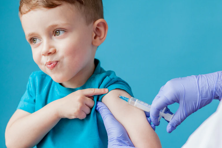 Cheeky looking buy getting a vaccine in upper arm