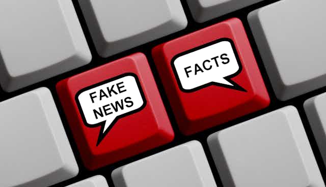 A computer keyboard with speech bubbles on two keys saying FAKE NEWS and FACTS