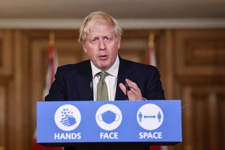 UK PM Boris Johnson at a speaker's podium.
