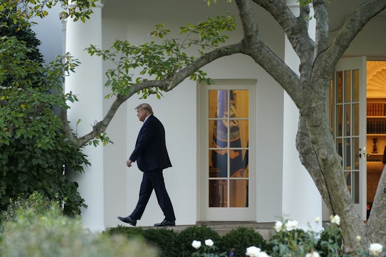 US President Donald Trump walking in front of the White House.
