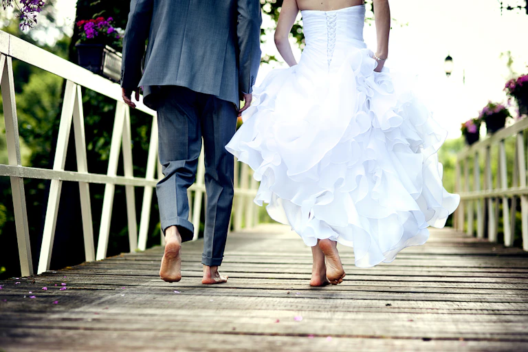 Bride and groom barefoot on a wooden deck or jetty