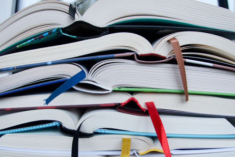 A pile of books, with ribbons sticking out to denote bookmarks