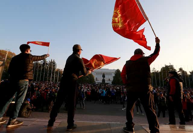 Supporters of Kyrgyzstan's new president Sadyr Japorov on the streets waving the national flag.